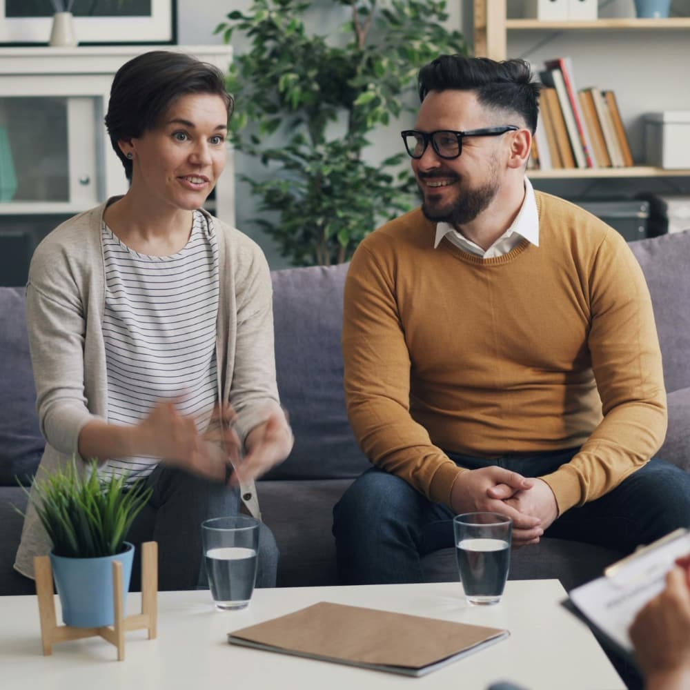 Couple smiling in a therapists office during mediation