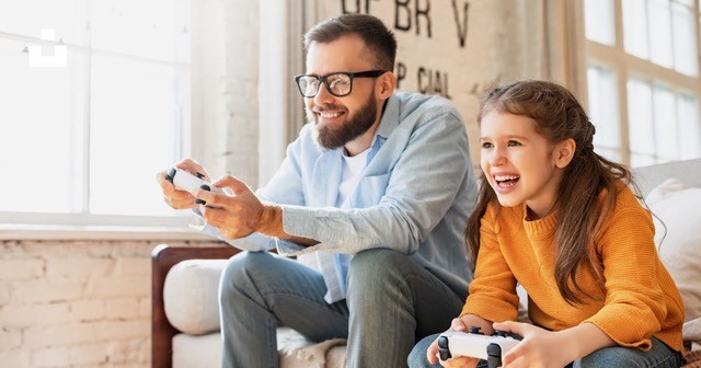 Dad playing video games with his daughter