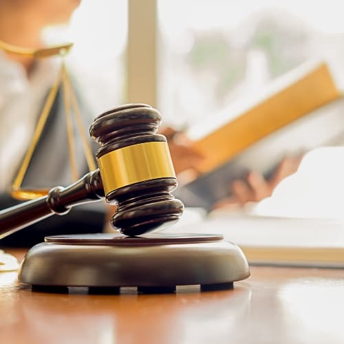 Gavel with person reading law documents