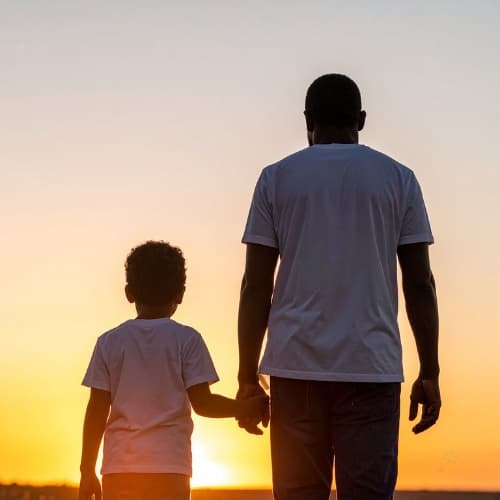 Father and son walking in the sunrise
