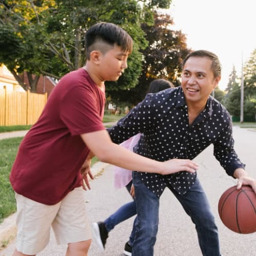 Father playing basketball with child