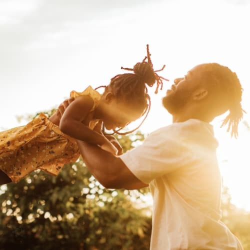Father spinning daughter around in a circle in the air