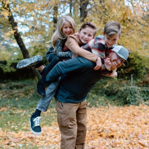 Father with children playing in the leaves