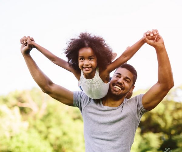 Father lifting daughter in the air flying through the sky